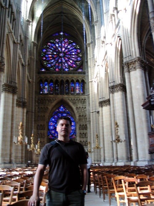 Bernard Burch in a cathedral, in front of its rose window