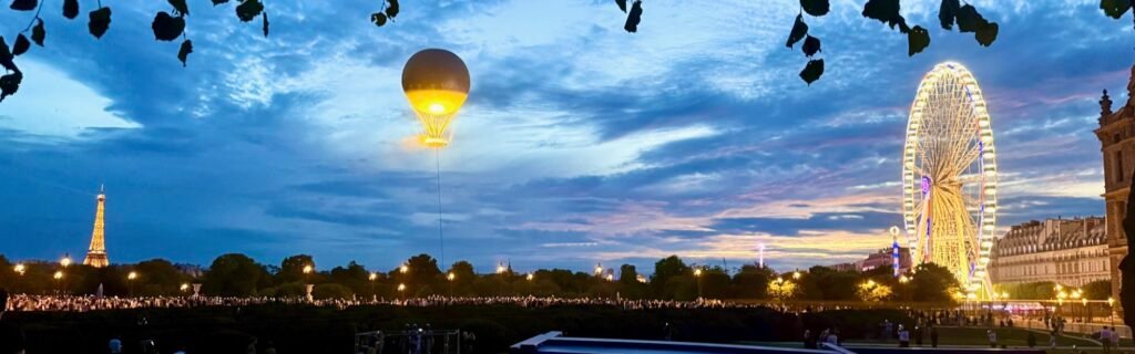 A hot-air balloon and a Ferris wheel over Paris at dusk